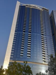 Tall modern skyscraper with blue glass facade and sleek design.